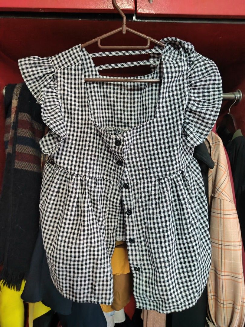 Black and white gingham ruffled blouse with button front (Category: Blouses) located in Caloocan City. Submitted by MovesLikeJeager (Listing ID 1470388637, Image 1). Description: - Pattern: Classic black & white checkered gingham - Design: Flutter sleeves with ruffles, square neckline, and slight peplum waist - Closure: Button-down front with dark buttons - Fabric: Lightweight and breathable, perfect for warm weather or layering - Styling: Versat