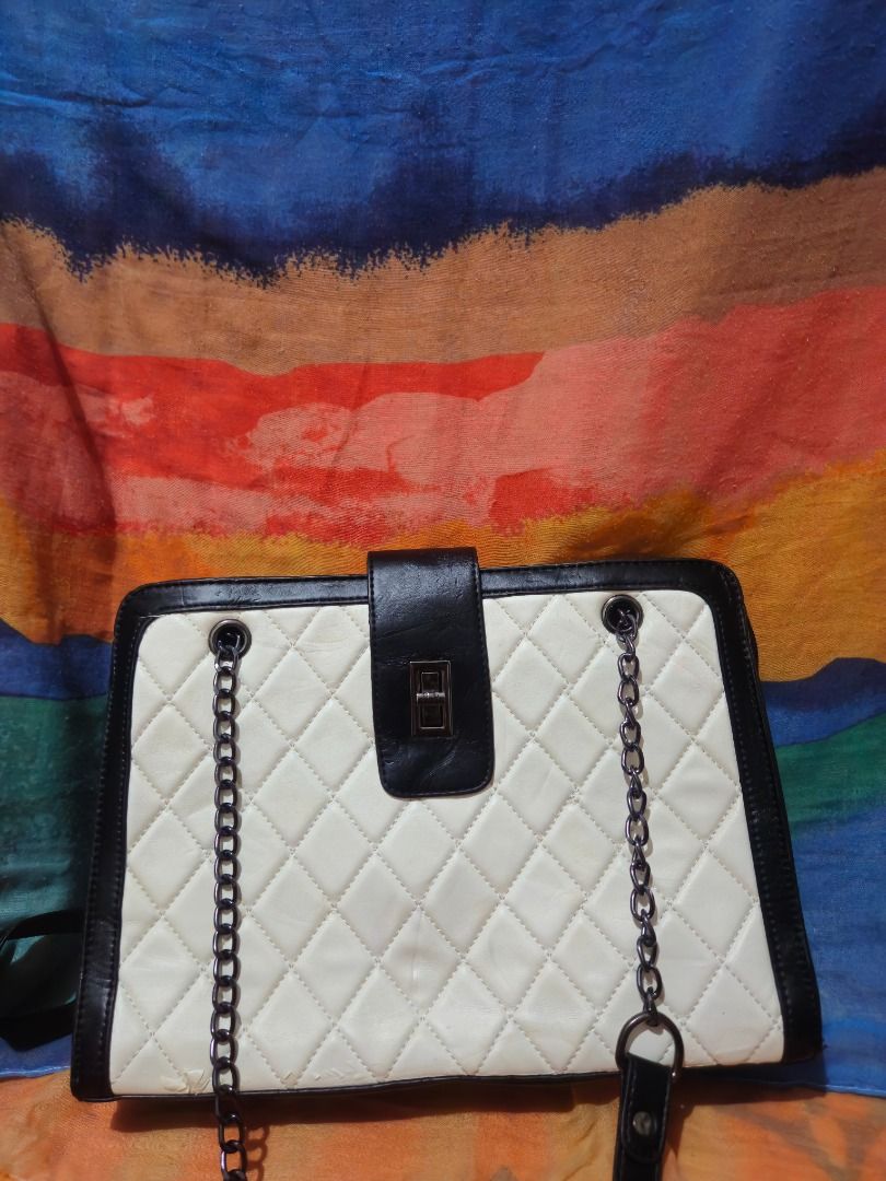Black and White Quilted Shoulder Bag with Chain Straps (Category: Shoulder Bags) located in Caloocan City. Submitted by gracevaultin.19 (Listing ID 1470547673, Image 2). Description: - Design: Classic black and white quilted pattern with structured rectangular shape and contrasting black trim - Closure: Center flap with a secure metallic twist lock - Straps: Dual shoulder straps combining black faux leather and dark metal chain hardware - Interio
