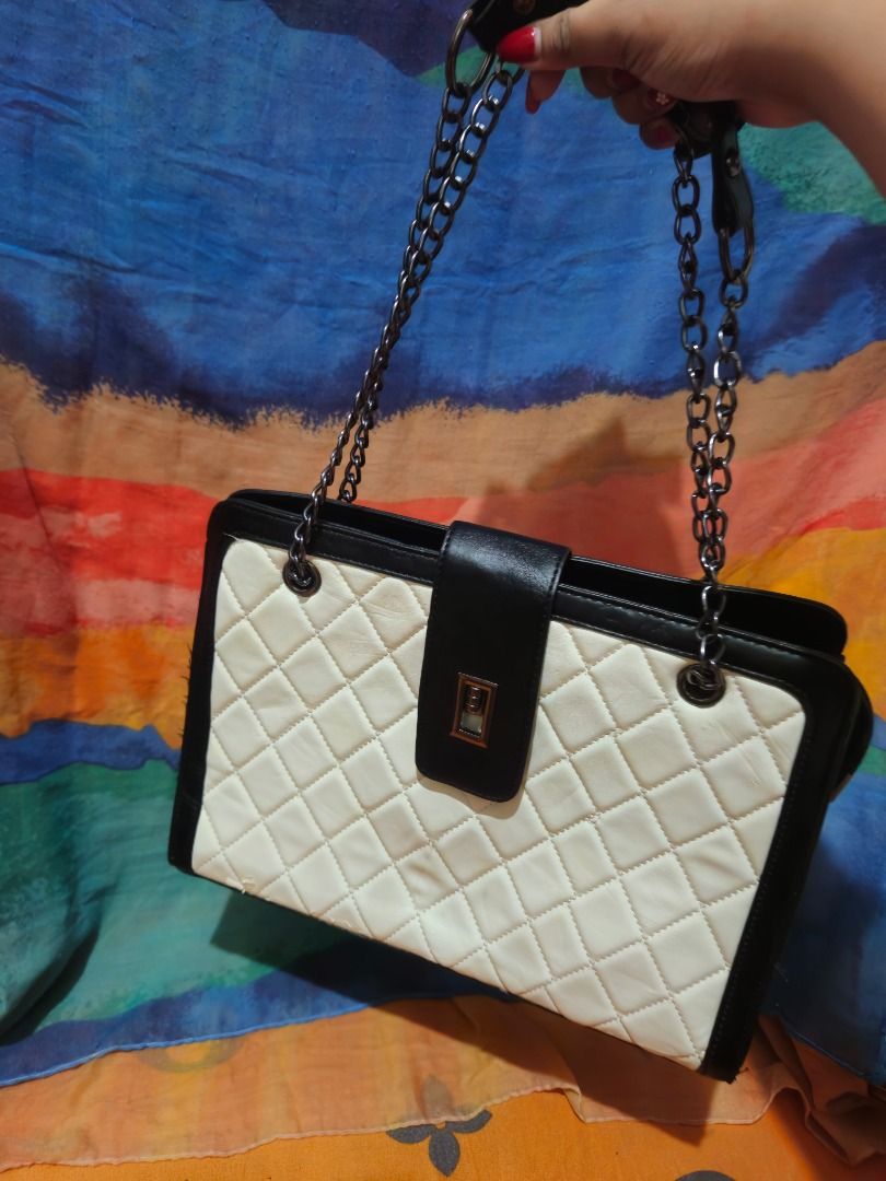Black and White Quilted Shoulder Bag with Chain Straps (Category: Shoulder Bags) located in Caloocan City. Submitted by gracevaultin.19 (Listing ID 1470547673, Image 3). Description: - Design: Classic black and white quilted pattern with structured rectangular shape and contrasting black trim - Closure: Center flap with a secure metallic twist lock - Straps: Dual shoulder straps combining black faux leather and dark metal chain hardware - Interio