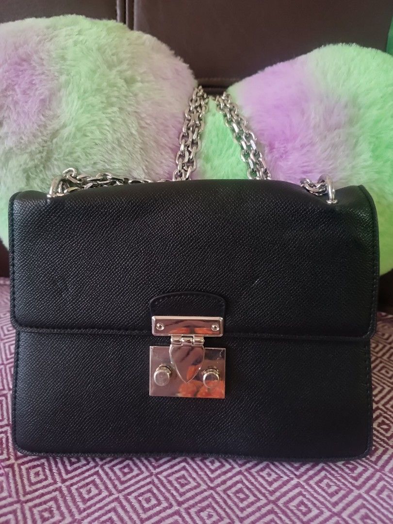 Black cross-body handbag with silver chain strap (Category: Cross-body Bags) located in Las Pinas. Submitted by mitchmiko16 (Listing ID 1470379001, Image 2). Description: - Material: Premium textured faux leather - Design: Structured rectangular shape with clean edge stitching - Hardware: Shiny silver metal push-lock closure - Strap: Versatile silver chain shoulder strap (can be doubled) - Capacity: Ideal size for daily essentials, phone, and key