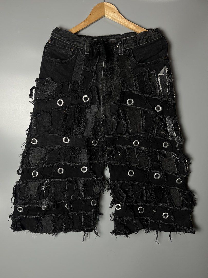 Black Distressed Patchwork Denim Shorts with Metal Eyelets (Category: Shorts) located in Dagupan City. Submitted by loves2thrifth (Listing ID 1470529327, Image 1). Description: - Style: Edgy streetwear black denim shorts - Details: Heavy patchwork, intentional distressing, and metal grommets throughout - Finish: Raw frayed edges and a dark faded wash - Fit: Drawstring waist with a branded button closure - Condition: Excellent unique piece, grab t