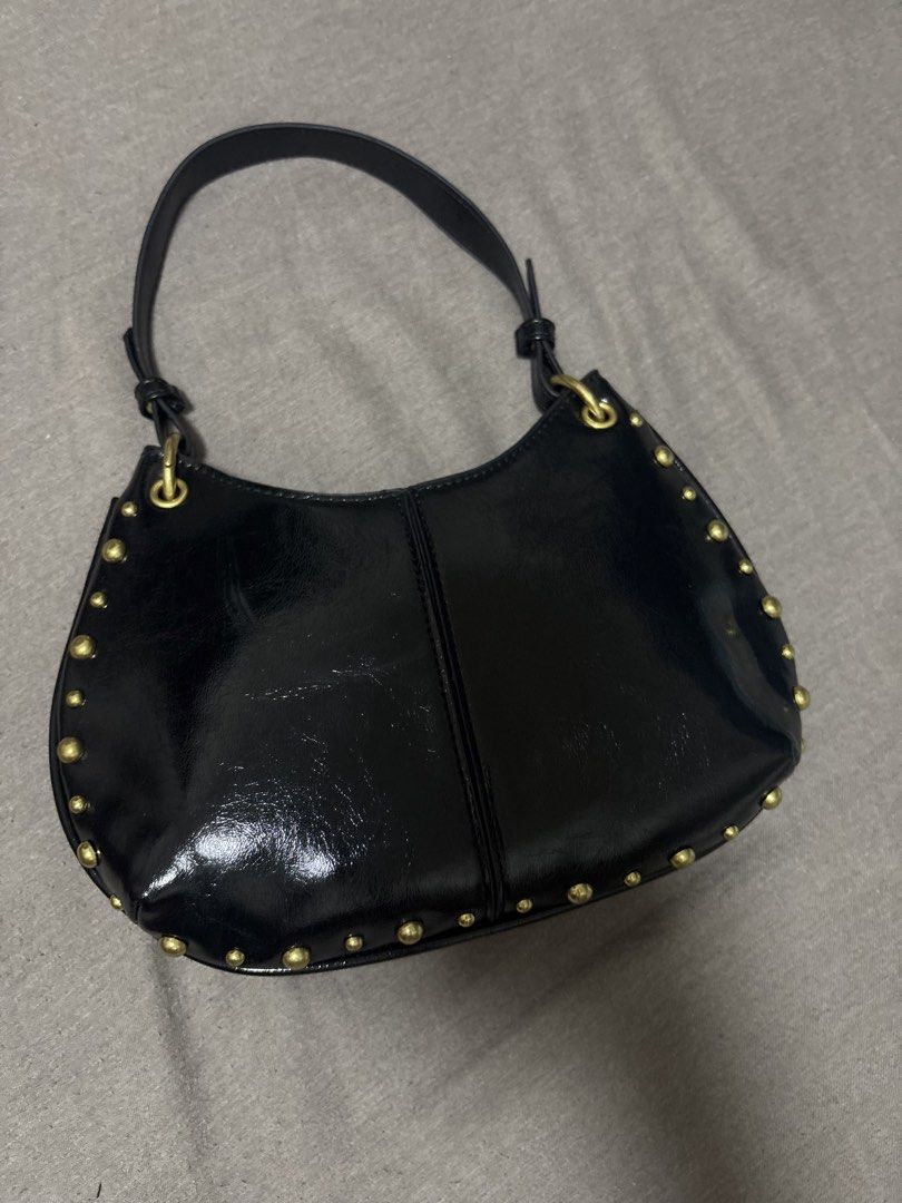 Black Studded Shoulder Bag with Gold Hardware (Category: Luxury Bags & Wallets) located in Caloocan City. Submitted by shopmyclosetttttt (Listing ID 1470399086, Image 2). Description: - Material: Glossy black faux leather - Details: Chic gold dome studs along curved edges and seams - Strap: Single strap with metal rings - Size: Compact hobo shape, fits phone, wallet, and daily essentials - Condition: Clean interior and exterior -It was a gift, so