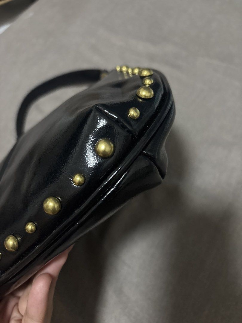 Black Studded Shoulder Bag with Gold Hardware (Category: Luxury Bags & Wallets) located in Caloocan City. Submitted by shopmyclosetttttt (Listing ID 1470399086, Image 3). Description: - Material: Glossy black faux leather - Details: Chic gold dome studs along curved edges and seams - Strap: Single strap with metal rings - Size: Compact hobo shape, fits phone, wallet, and daily essentials - Condition: Clean interior and exterior -It was a gift, so