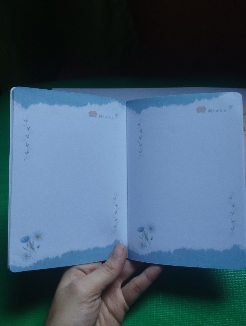 Blue Aesthetic Notebook with Windchime and Blossom Design (Category: Stationery & School Supplies) located in San Mateo. Submitted by diana_01.tree (Listing ID 1470351136, Image 3). Description: - Design: Blue aesthetic cover with windchime and cherry blossom graphic; Japanese text on the back cover - Pages: with designs inside pages - Condition: Brand new, pretty clean pages - Perfect for: Journaling, note-taking, or schoolwork - thin, pocket si