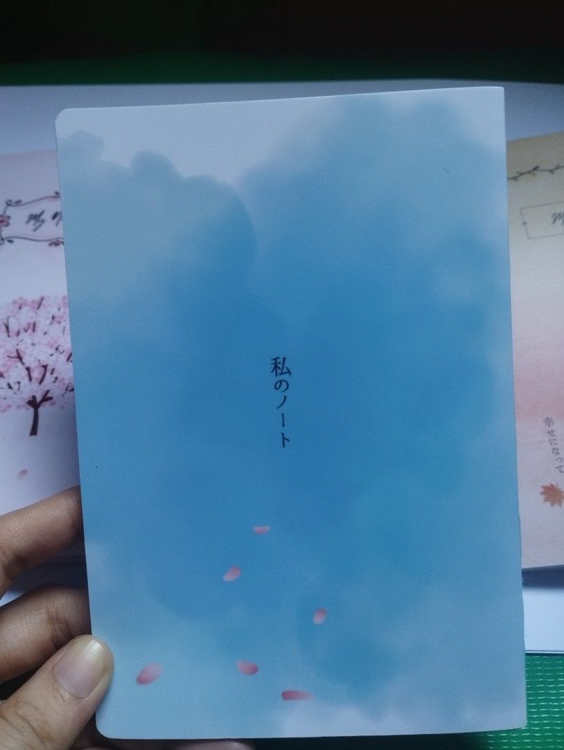 Blue Aesthetic Notebook with Windchime and Blossom Design (Category: Stationery & School Supplies) located in San Mateo. Submitted by diana_01.tree (Listing ID 1470351136, Image 2). Description: - Design: Blue aesthetic cover with windchime and cherry blossom graphic; Japanese text on the back cover - Pages: with designs inside pages - Condition: Brand new, pretty clean pages - Perfect for: Journaling, note-taking, or schoolwork - thin, pocket si