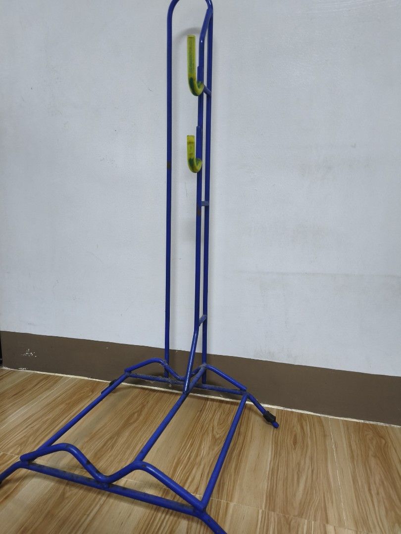 Blue Bike Stand (Heavy Duty) (Category: Bicycles) located in Alaminos. Submitted by fayesbook (Listing ID 1470408456, Image 3). Description: - Blue metal vertical bicycle stand - Fits one bike securely by the wheel and frame - Yellow rubberized hooks keep the frame steady - Sturdy base prevents tipping and saves garage space - Condition: Minor rust spots on the metal frame from previous use.