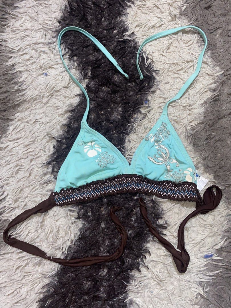 Blue Butterfly Halter (Category: Bikinis & Swimsuits) located in Caloocan City. Submitted by remythrift (Listing ID 1470350456, Image 1). Description: - Style: Halter bikini top - Color/Design: Light blue with white hibiscus prints and silver butterfly graphic on right cup - Details: Brown braided underband and contrast stitching - Fit: Adjustable neck and back ties.