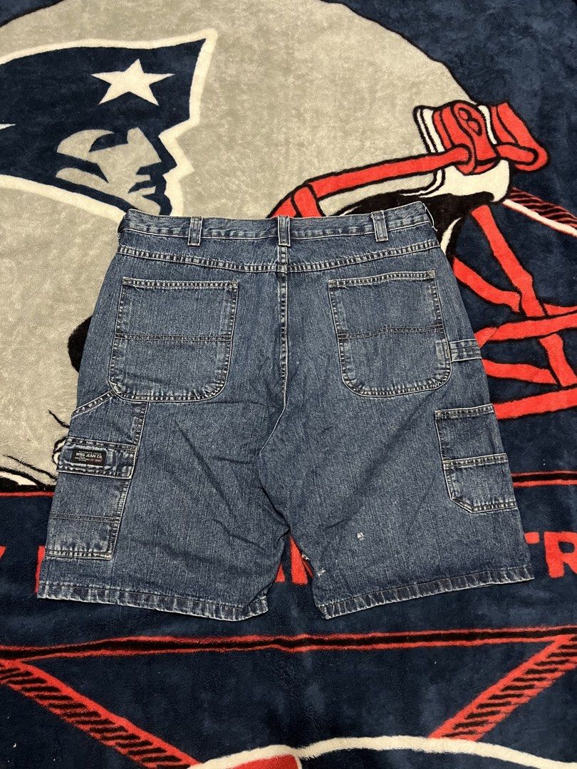 Blue Denim Cargo Shorts (Category: Shorts) located in Tanza. Submitted by 1954_street (Listing ID 1470378945, Image 1). Description: WRANGLER CARPENTER JORTS 38 waist 23 length 13 leg opening minor tattered holes 500 - Style: Classic skater / workwear fit - Color/Material: Blue denim - Features: Multiple utility pockets, regular belt loops, and button closure - Condition: Good with minor fraying and small distress marks near the hem as pictured.