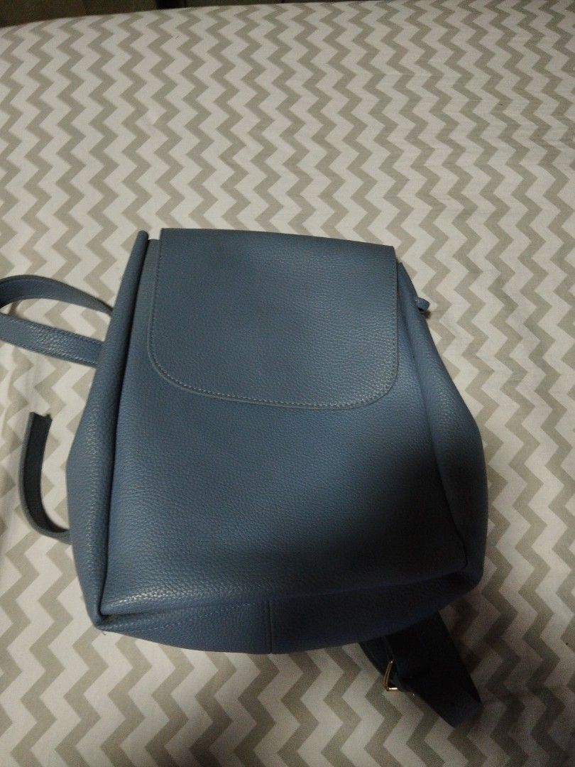 Blue leather backpack with flap closure and adjustable straps (Category: Backpacks) located in Manila. Submitted by lene48 (Listing ID 1470349548, Image 1). Description: Textured blue leather backpack with front flap and magnetic snap closure. Includes a top grab handle and adjustable shoulder straps on the back. Drawstring closure under the main flap. Compact size for daily essentials. Clean stitching throughout .