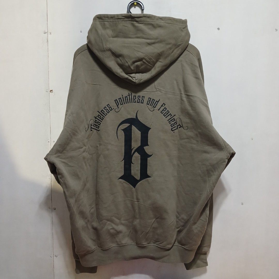 Boneless Green Hoodie Size L (Category: Hoodies) located in Manila. Submitted by joefrey12 (Listing ID 1470452037, Image 2). Description: - Brand: Boneless - Color: Olive Green - Size: L (170/92A), 25x27 - Material: Comfortable heavyweight cotton - Design: Small gothic chest logo, large gothic back graphic with 'Tasteful and Fearless' text - Features: Front kangaroo pocket, ribbed cuffs and hem - Style: Perfect for streetwear looks.