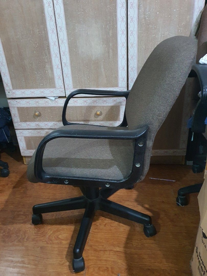Brown rolling office chair with armrests (Category: Office Furniture & Fixtures) located in Paranaque City. Submitted by nicessities (Listing ID 1470394301, Image 2). Description: - brown fabric upholstery with noticeable wear marks and stains - Black plastic armrests and five-star wheeled base - Height adjustable stem with standard swivel mechanism - Solid construction that rolls smoothly across wooden floors needs cleaning if maselan. this was 