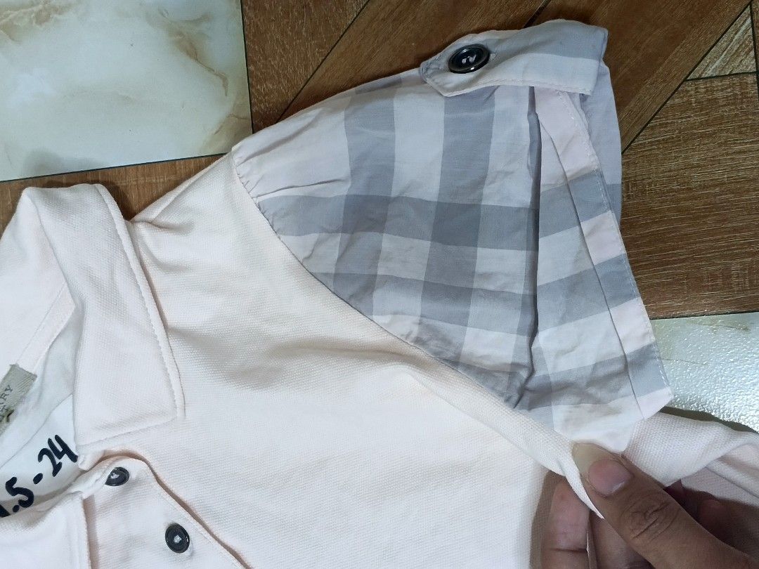 Burberry Light Pink Polo Shirt Size S (Category: Blouses) located in Manila. Submitted by dp.finds (Listing ID 1470501321, Image 2). Description: - Brand: Burberry - Color: Light pink - Size: S (Bust: 85cm) - Material: 98% cotton, 2% elastane for a comfortable stretch - Design: Classic button placket with trendy checkered pattern and button tabs on short sleeves - Care: Machine washable - Condition: Excellent.