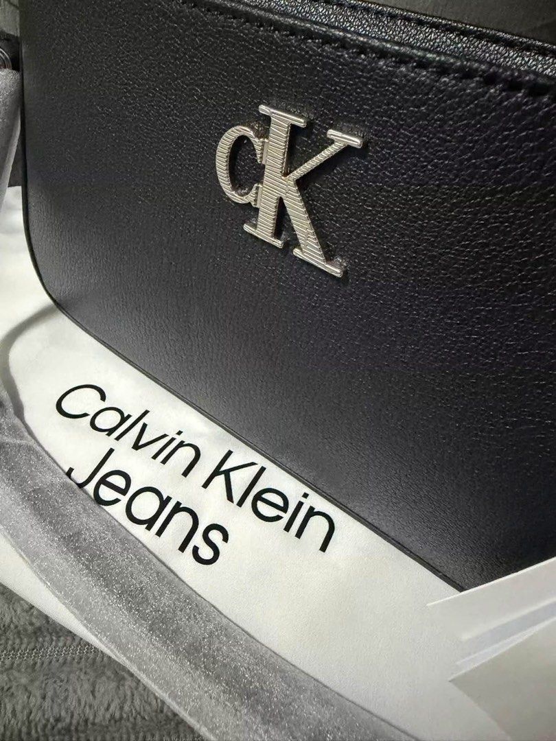 Calvin Klein Jeans Black Shoulder Bag (Category: Shoulder Bags) located in Calamba. Submitted by saiphsavion (Listing ID 1470451334, Image 1). Description: - Brand: Calvin Klein Jeans - Color: Classic Black - Material: Textured faux leather with silver metallic CK logo - Closure: Secure top zip - Interior: Fabric-lined with convenient slip pocket - Inclusions: Original store tags attached and branded dust bag included - Condition: Brand new, 100%