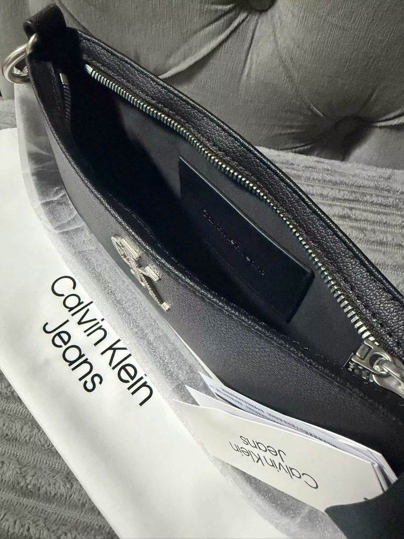 Calvin Klein Jeans Black Shoulder Bag (Category: Shoulder Bags) located in Calamba. Submitted by saiphsavion (Listing ID 1470451334, Image 2). Description: - Brand: Calvin Klein Jeans - Color: Classic Black - Material: Textured faux leather with silver metallic CK logo - Closure: Secure top zip - Interior: Fabric-lined with convenient slip pocket - Inclusions: Original store tags attached and branded dust bag included - Condition: Brand new, 100%