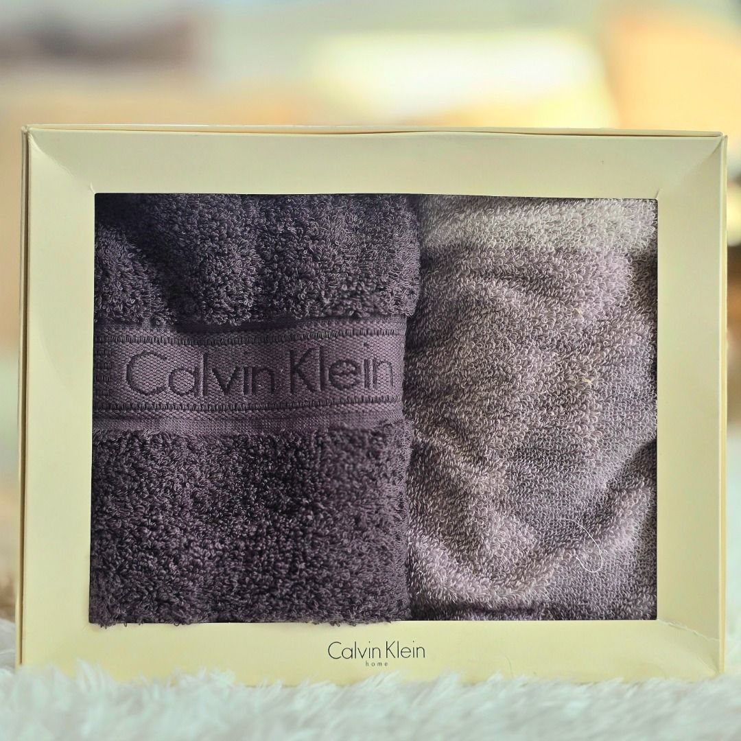 Calvin Klein Towel Gift Set (Category: Bedding & Towels) located in Compostela. Submitted by curatedcabinetcebu (Listing ID 1470544145, Image 1). Description: - Brand: Calvin Klein - Item: Matching towel set - Colors: Deep purple and shimmering taupe - Design: Bold Calvin Klein logo band on one towel - Condition: Unused, brand new - Packaging: Comes in an elegant cream gift box All brand names and trademarks belong to their respective owners. Cur