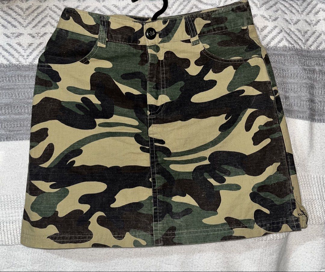 Camouflage Denim Mini Skirt Size S (Category: Skirts) located in General Mariano Alvarez. Submitted by kascade (Listing ID 1470461937, Image 2). Description: - Color/Print: Green camouflage - Material: Sturdy ripstop cotton - Size: S (tag attached) - Fit: Structured straight fit, finishes above the knee - Features: Classic 4-pocket design, belt loops, front button closure, and zip fly - Condition: Great everyday piece for casual streetwear 💵 Pay