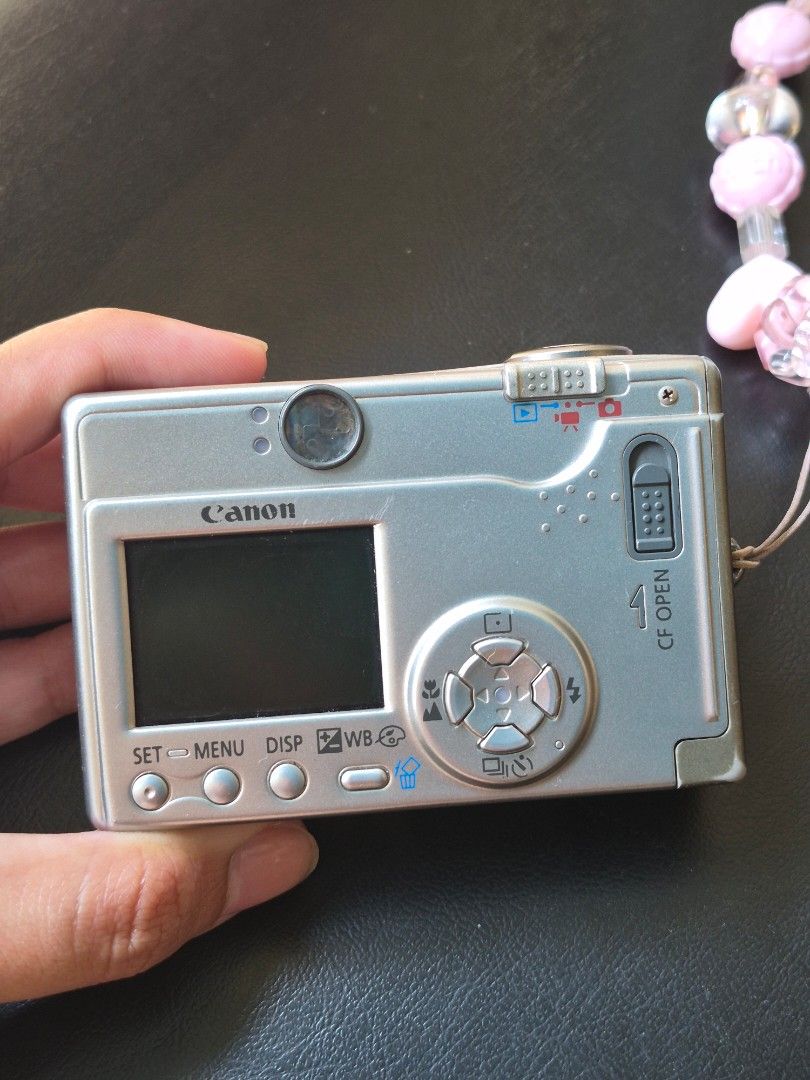 Canon PowerShot S200 Digital ELPH Compact Camera (Category: Cameras) located in Manila. Submitted by its_geliiii (Listing ID 1470392006, Image 2). Description: FOR SALE: Canon PowerShot S200 Digital ELPH — DEFECTIVE / FOR REPAIR Selling my Canon PowerShot S200 Digital ELPH, 2MP vintage digital camera. **Condition and issues:** * Powers on and lens extends normally * LCD menu displays properly * Previously saved photos can be viewed * Live view is