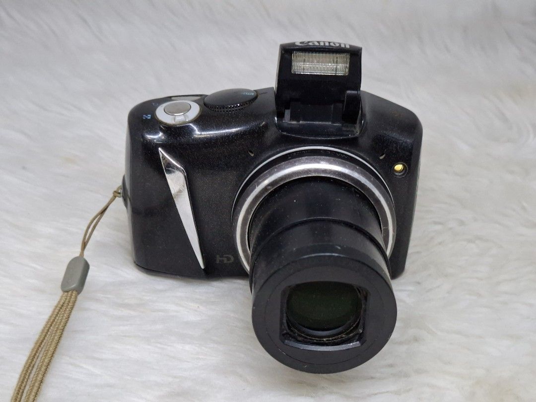 Canon PowerShot sx130is ccd sensor (Category: Cameras) located in Manila. Submitted by jonrick.co (Listing ID 1470457561, Image 1). Description: - Black Canon compact digital camera - Features built-in zoom lens and pop-up flash - Working rear LCD screen with menu settings (digital zoom, AF-point zoom) - Equipped with physical buttons and navigation wheel for easy control - Includes attached wrist strap - Condition: Body shows minor surface dust 