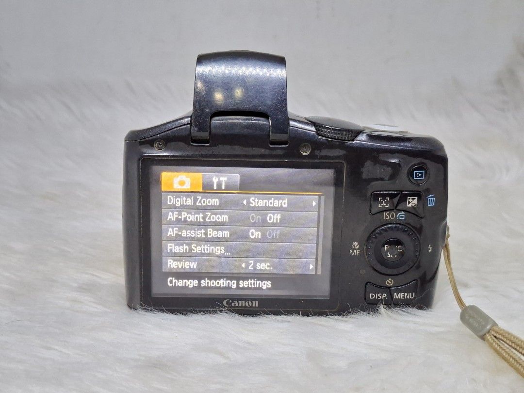 Canon PowerShot sx130is ccd sensor (Category: Cameras) located in Manila. Submitted by jonrick.co (Listing ID 1470457561, Image 3). Description: - Black Canon compact digital camera - Features built-in zoom lens and pop-up flash - Working rear LCD screen with menu settings (digital zoom, AF-point zoom) - Equipped with physical buttons and navigation wheel for easy control - Includes attached wrist strap - Condition: Body shows minor surface dust 