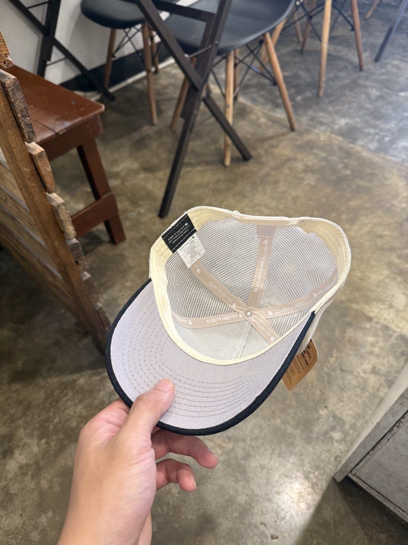 Carhartt Trucker Hat Off White Black Snapback (Category: Caps & Hats) located in Pozorrubio. Submitted by kulin_ (Listing ID 1470495800, Image 3). Description: - Brand: Carhartt - Condition: Brand new with original tag attached - Color: Off-white and black - Design: Structured front with a curved brim and breathable mesh back panels - Details: Classic brown leather Carhartt logo patch on the front - Fit: Adjustable white snapback closure.