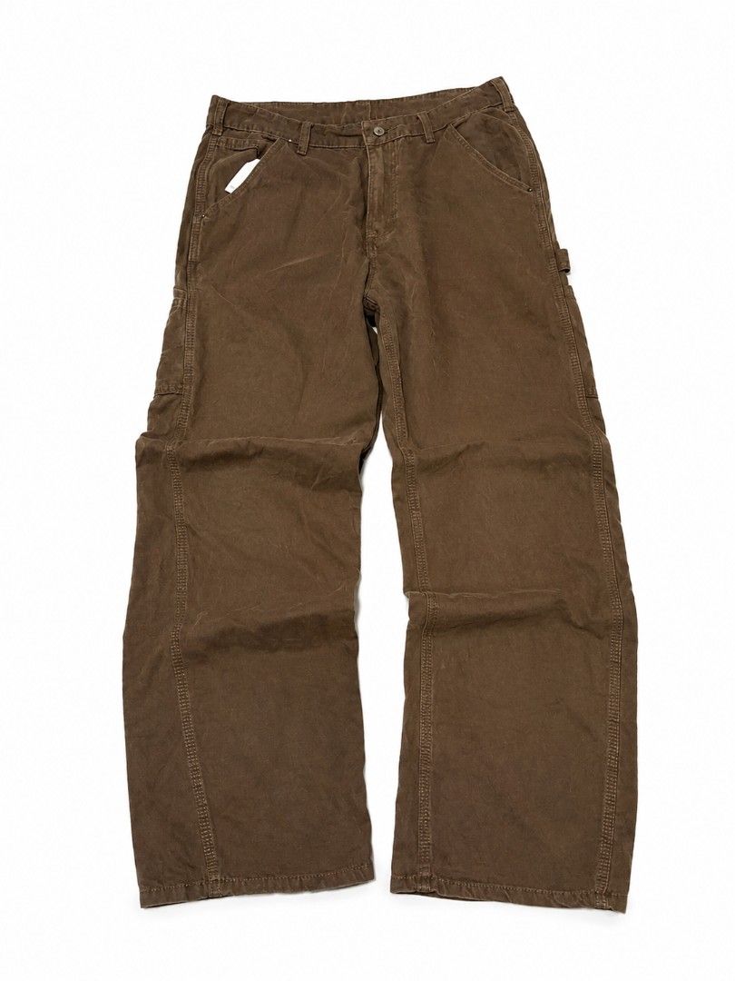 Carpenter pants Work Pants (Category: Jeans) located in Urdaneta. Submitted by goldeneagle-e662 (Listing ID 1470474027, Image 2). Description: - Brand: Carhartt - Style: Double-knee carpenter pants / Workwear - Color: Versatile brown - Material: Rugged, durable cotton duck fabric - Fit: Straight relaxed fit through the leg - Features: Hammer loop, side utility pockets, and back patch pockets - Details: Iconic woven Carhartt logo patch on the back