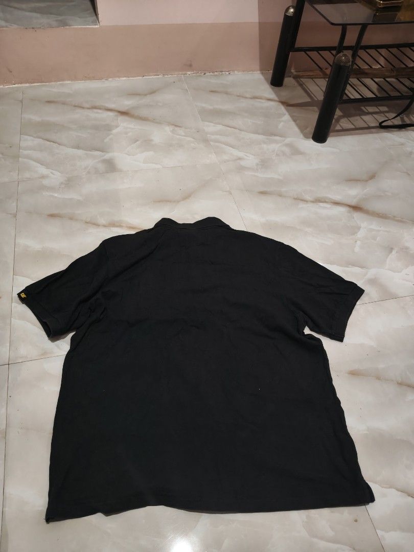 Caterpillar CAT Black Polo Shirt (Category: Tshirts & Polo Shirts ) located in Rizal, Mindoro Occidental. Submitted by finding_ukaygems5103 (Listing ID 1470528992, Image 2). Description: - Brand/Model: Caterpillar Polo Shirt - Size: XL (Classic Fit) - Color: Black with white embroidered script logo on chest - Material: 100% breathable cotton - Details: Two-button placket, signature CAT tag on left sleeve hem and inner collar - Condition/Style: Ve