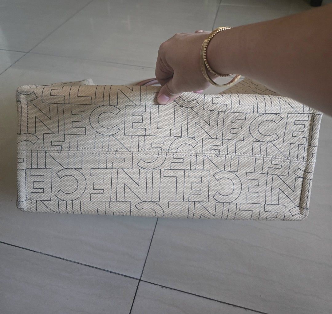 Celine Canvas Tote Bag with (Category: Tote Bags) located in Manila. Submitted by brandedshoppe_mnl (Listing ID 1470554301, Image 3). Description: -Authentic Celine tote bag in cream canvas with all-over logo print and brown leather handles. -Preloved and in good cpndition -Large Triomphe emblem on the front. -Structured rectangular shape with flat base. - Includes a black Celine dust bag. Clean canvas inside and out, sturdy leather top handles..