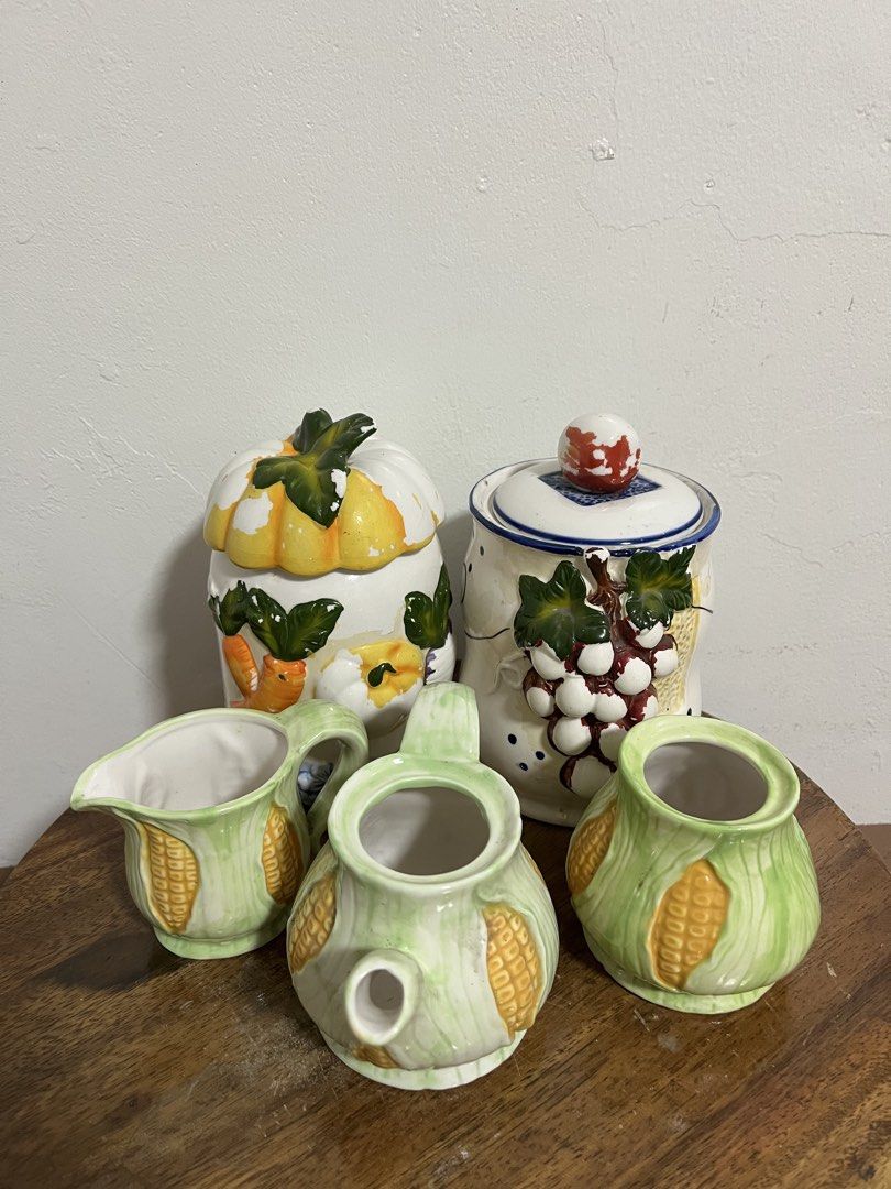 Ceramic Fruit and Vegetable Kitchen Canister Set (Category: Food Organization & Storage) located in Cabuyao City. Submitted by rdtrmt (Listing ID 1470480327, Image 1). Description: - Set of two charming ceramic storage jars with removable lids along with three small ceramic teapots - Jar 1 features playful 3D grapes with leaves and blue polka dots - Jar 2 showcases hand-painted pumpkins, carrots, and a delicate blue floral trim - The small teapot
