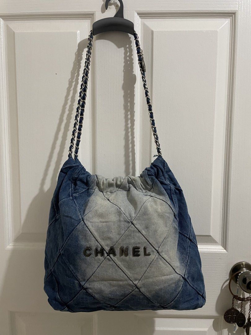Chanel Denim Quilted Shoulder Bag (Category: Luxury Bags & Wallets) located in Naga. Submitted by thriftboss88 (Listing ID 1470481706, Image 1). Description: - Brand: Chanel - Material: Blue and light wash denim - Design: Quilted diamond pattern with bold Chanel front lettering - Hardware & Straps: Silver-tone interwoven chain with leather and a branded round metal charm - Closure: Open top with gathered drawstring detail - Condition: Excellent (