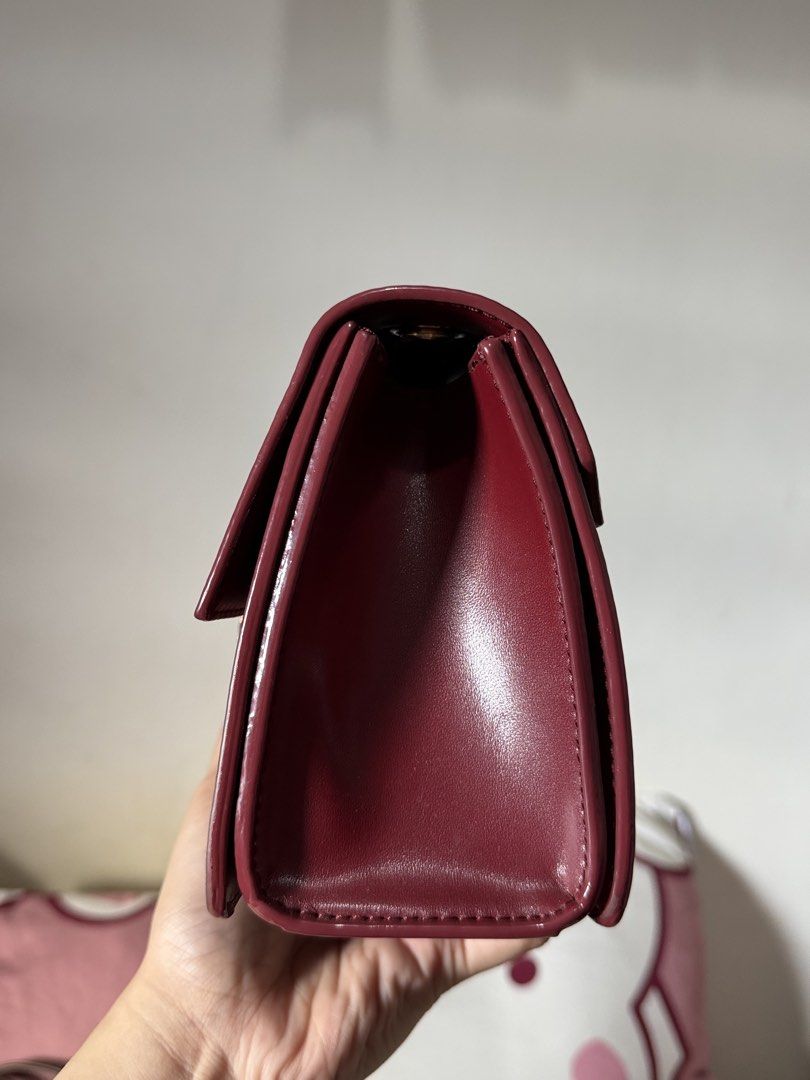 Charles & Keith Maroon Crossbody Bag (Category: Cross-body Bags) located in Lipa City. Submitted by asleeeh (Listing ID 1470349278, Image 2). Description: - Brand: Charles & Keith - Color: Rich maroon with elegant gold-tone hardware - Style: Crossbody bag featuring a stylish chain accent and round closure detail - Strap: Includes an adjustable strap for a customized fit - Storage: Convenient back zip pocket and interior zipped compartment - Inter