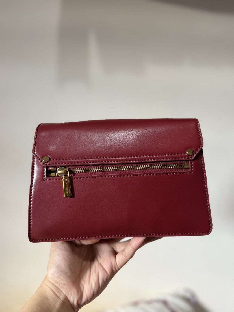 Charles & Keith Maroon Crossbody Bag (Category: Cross-body Bags) located in Lipa City. Submitted by asleeeh (Listing ID 1470349278, Image 3). Description: - Brand: Charles & Keith - Color: Rich maroon with elegant gold-tone hardware - Style: Crossbody bag featuring a stylish chain accent and round closure detail - Strap: Includes an adjustable strap for a customized fit - Storage: Convenient back zip pocket and interior zipped compartment - Inter