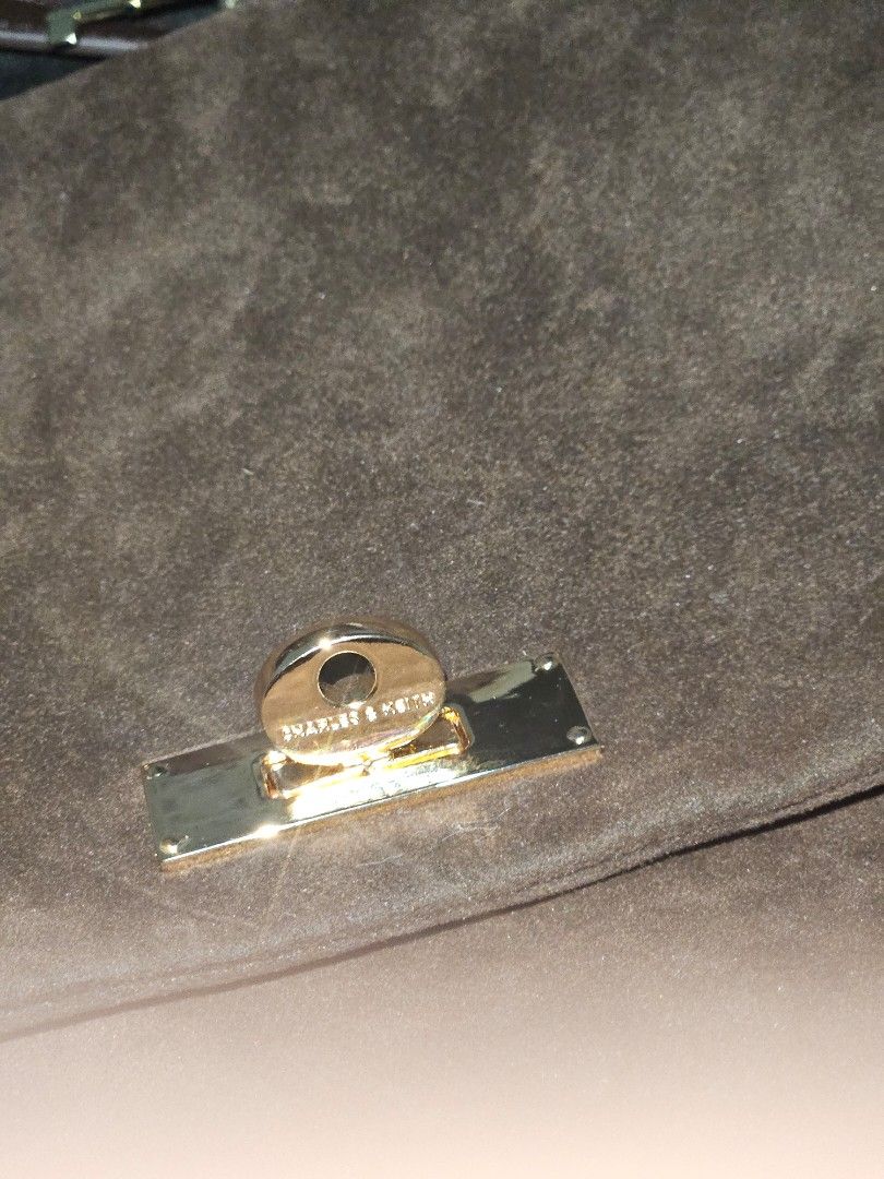 Charles & Keith Suede Brown handbag (w/ sling) (Category: Luxury Bags & Wallets) located in Quezon City. Submitted by maraclara007 (Listing ID 1470455410, Image 2). Description: - Brand: Charles & Keith - Material: Rich brown suede - Hardware: Gold-tone with turn-lock closure - Details: Decorative key charms on the strap - Strap: Includes long shoulder strap - Inclusions: Original dust bag - Condition: Clean interior, well-kept exterior - Feature