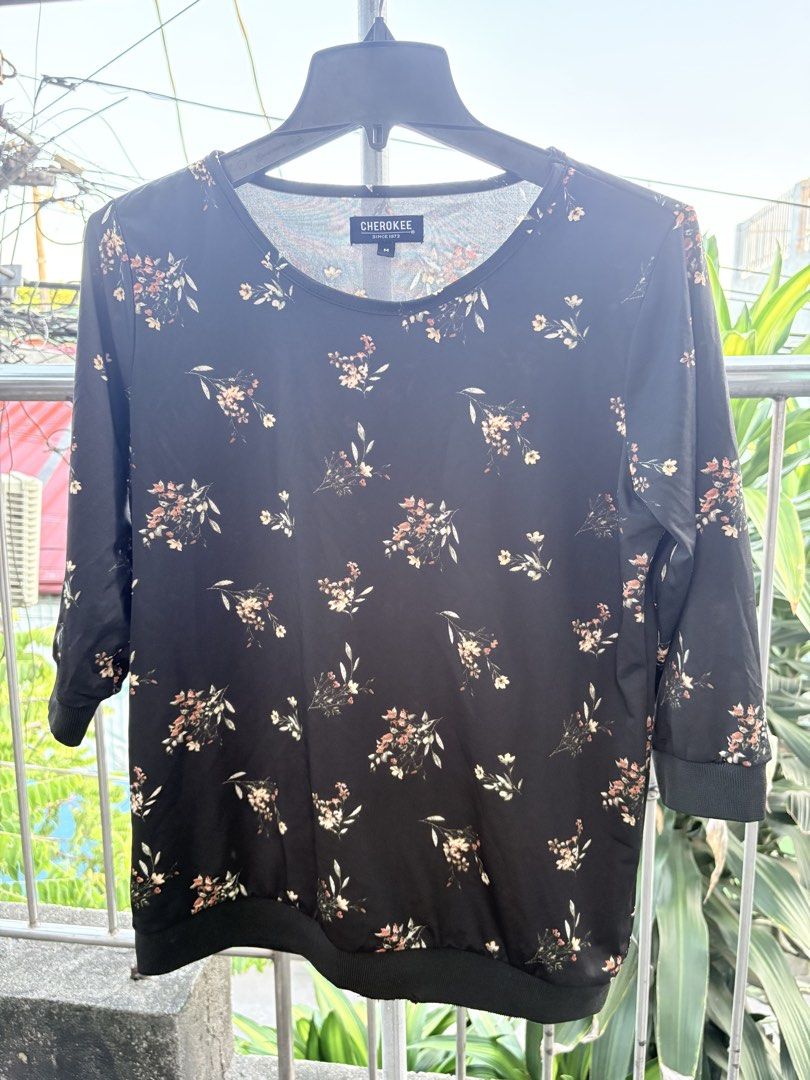 Cherokee Black Floral Blouse (Category: Blouses) located in Cavite. Submitted by earthread (Listing ID 1470452841, Image 1). Description: - Brand: Cherokee - Size: Medium - Design: Black with all-over small floral print - Features: Rounded neckline, three-quarter sleeves, ribbed cuffs and hem - Material: Lightweight and smooth - Condition: Excellent, clean with no stains or damage - Versatility: Perfect for casual wear or the office.