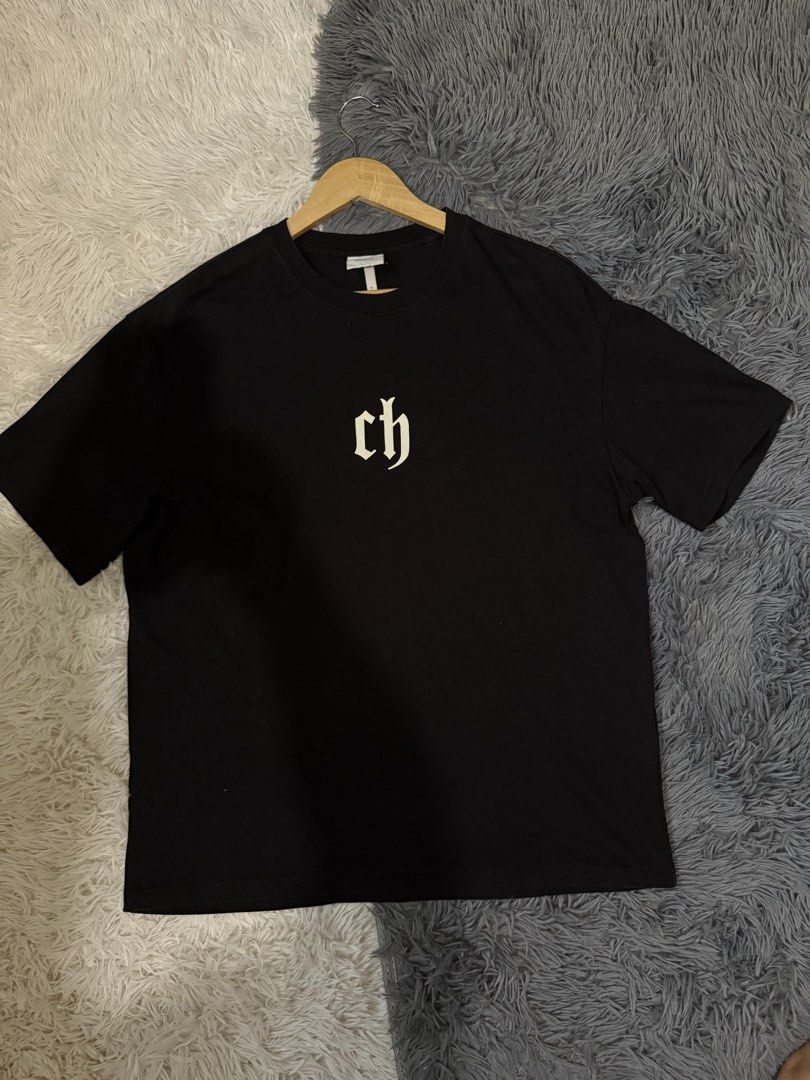 Chinistm Black Graphic Tee Size S (Category: Tshirts & Polo Shirts ) located in Manila. Submitted by keepercollection (Listing ID 1470376833, Image 1). Description: - Brand: Chinistm - Color: Black short sleeve t-shirt - Design: White gothic CH logo printed on the chest - Size: S (Marked 165/88A) - Measurements: ~22" pit to pit, ~29" total length - Material: Heavyweight cotton - Condition: Clean and ready to wear.