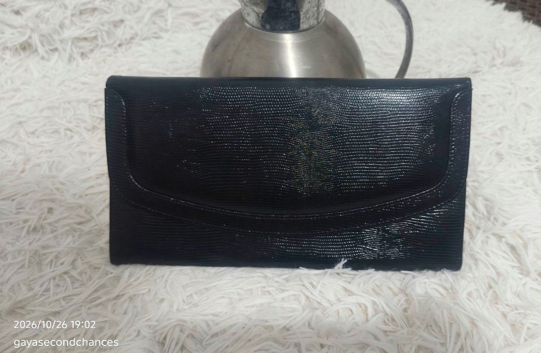 CLASSIC TEXTURED CLUTCH (Category: Clutches) located in Kalibo. Submitted by secondchances.thriftsh8p (Listing ID 1470312489, Image 1). Description: - Color: Classic black - Material: Textured faux lizard skin finish - Closure: Secure flap with snap button - Design: Sleek profile with clean edge stitching - Capacity: Compact size fits cards, cash, and phone easily - Versatility: Minimalist style, perfect for dinners and events.