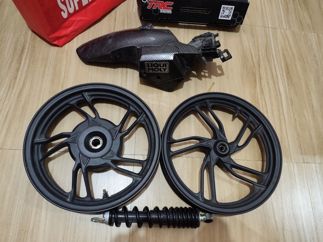 Click 125i Parts (Category: Mags and Tires) located in Manila. Submitted by villanueva97840 (Listing ID 1470474741, Image 1). Description: - Black cast wheels - Single rear shock absorber - Carbon-pattern rear mudguard with Liqui Moly sticker - Removed from a scooter upgrade project - Shows normal wear on components - Note: TRC Racing box in background is for display only.