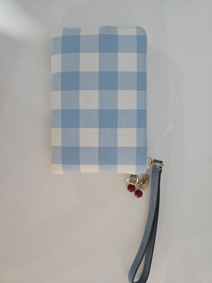 Coach Blue Gingham Print Wristlet Pouch with Cherry Charm (Category: Purses & Pouches) located in Quezon City. Submitted by purinthriftshop (Listing ID 1470364396, Image 2). Description: - Brand: Coach - Design: Blue and white gingham print canvas with gold-tone hardware and front logo - Strap: Blue leather wrist strap - Accent: Cute cherry charm on the zipper pull - Closure: Secure zip top - Condition: Clean inside and out, from a smoke-free hom