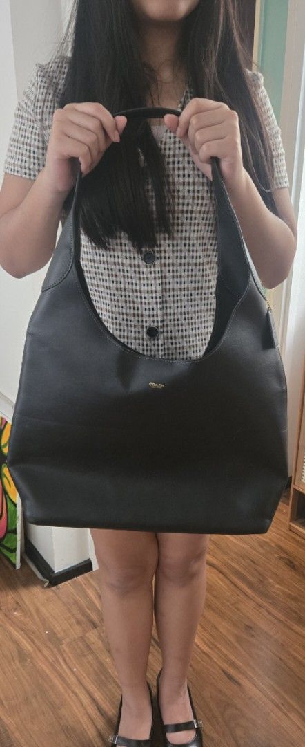 Coach Bootklyn Hobo Leather Shoulder Bag (Category: Luxury Bags & Wallets) located in Quezon City. Submitted by PreLovedByMrsAL (Listing ID 1470379135, Image 3). Description: - Brand: Coach - Material: Soft black leather with matching hardware - Design: Slouchy shoulder bag with a thin, comfortable strap - Details: Gold front lettering and signature hangtag - Condition: Clean inside and out with minimal wear - Capacity: Spacious interior for all 