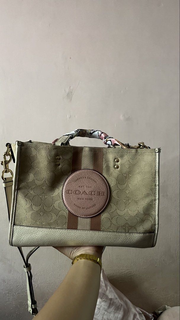 Coach Dempsey Carryall Slingbag (Category: Tote Bags) located in Davao. Submitted by kanto-10 (Listing ID 1470378117, Image 1). Description: - Authentic Coach signature canvas tote bag - Cream base with chic pink and brown vertical stripes - Features a round leather patch logo and luxury gold-tone hardware - Spacious interior compartment with dark lining - Includes a detachable crossbody strap for versatile wear - Comes with a stylish pink patter
