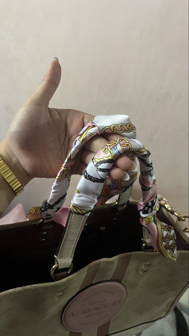 Coach Dempsey Carryall Slingbag (Category: Tote Bags) located in Davao. Submitted by kanto-10 (Listing ID 1470378117, Image 3). Description: - Authentic Coach signature canvas tote bag - Cream base with chic pink and brown vertical stripes - Features a round leather patch logo and luxury gold-tone hardware - Spacious interior compartment with dark lining - Includes a detachable crossbody strap for versatile wear - Comes with a stylish pink patter