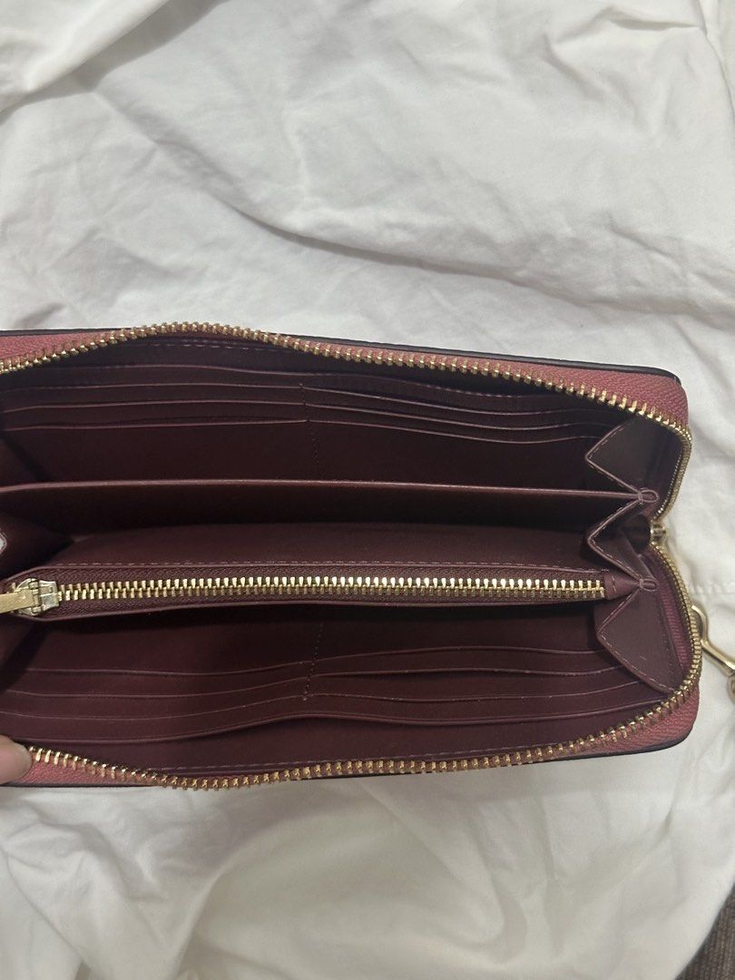 Coach Long Zip Around Wallet Rose Pink (Category: Wallets & Card holders) located in San Juan City. Submitted by biatchhhh (Listing ID 1470496937, Image 2). Description: - Authentic Coach long zip around wallet - Material: Rose pink pebbled leather with gold-tone hardware - Interior: Dark burgundy lining with multiple card slots, bill compartments, and a middle zippered coin pocket - Condition: Clean inside and out no scratches - Hardware: Smooth