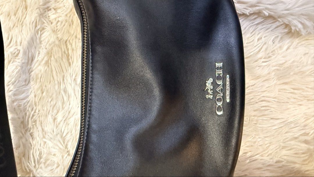 Coach Pace Shoulder Bag (Category: Luxury Bags & Wallets) located in Pasay City. Submitted by erinsclosetph (Listing ID 1470361007, Image 3). Description: Coach Pace Black Shoulder Bag Curved crescent hobo silhouette, silver-tone hardware, top zip closure with an adjustable fabric shoulder strap. Very good condition. Flaws: slight tarnishing on hardware and hairline scratches on the leather Measurements: 15 × 29 × 12 cm..