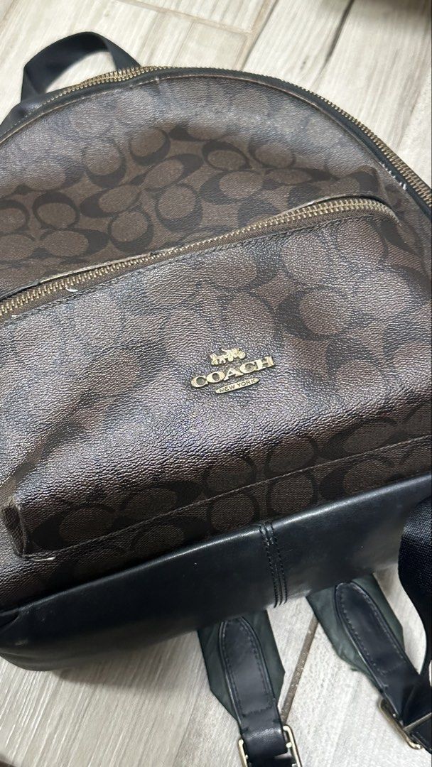 Coach Signature Canvas Leather Backpack Dark Brown Black (Category: Backpacks) located in Quezon City. Submitted by rccola__ (Listing ID 1470375993, Image 2). Description: - Brand: Coach - Material: Signature monogram canvas with black leather trim - Color: Dark brown with black and gold-tone hardware - Compartments: Roomy main compartment with zip closure and front zip pocket - Details: Coach New York logo stamp, dual shoulder straps, top grab h