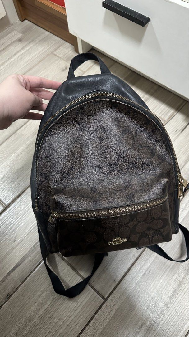 Coach Signature Canvas Leather Backpack Dark Brown Black (Category: Backpacks) located in Quezon City. Submitted by rccola__ (Listing ID 1470375993, Image 1). Description: - Brand: Coach - Material: Signature monogram canvas with black leather trim - Color: Dark brown with black and gold-tone hardware - Compartments: Roomy main compartment with zip closure and front zip pocket - Details: Coach New York logo stamp, dual shoulder straps, top grab h