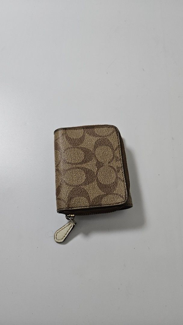 Coach Signature Canvas Small Tri-fold Wallet Brown (Category: Luxury Bags & Wallets) located in Alfonso. Submitted by jbcamet (Listing ID 1470401982, Image 2). Description: - Brand: Coach - Material: Signature brown coated canvas with smooth brown leather lining - Design: Tri-fold with secure snap closure - Features: Clear ID window, multiple card slots, full-length bill compartment, and side zippered coin pocket - Condition: Clean with normal si