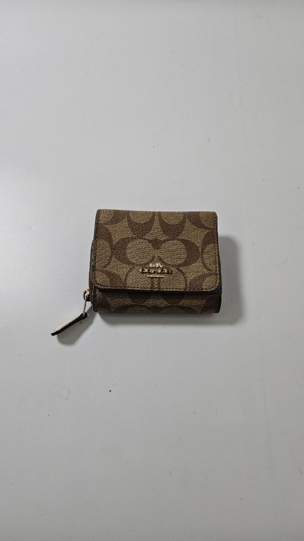 Coach Signature Canvas Small Tri-fold Wallet Brown (Category: Luxury Bags & Wallets) located in Alfonso. Submitted by jbcamet (Listing ID 1470401982, Image 1). Description: - Brand: Coach - Material: Signature brown coated canvas with smooth brown leather lining - Design: Tri-fold with secure snap closure - Features: Clear ID window, multiple card slots, full-length bill compartment, and side zippered coin pocket - Condition: Clean with normal si