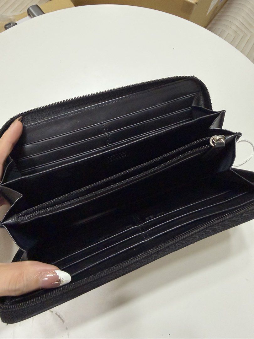 Coach wallet (Category: Wallets & Card holders) located in Cavite. Submitted by aljennaaaa (Listing ID 1470542454, Image 3). Description: - Authentic Coach zip-around wallet - Black signature C fabric with center leather stripe and debossed logo patch - Multiple card slots and slip compartments for organization - Secure zippered coin pocket - Smooth black leather lining - Clean condition, inside and out - Standard zip closure with leather pull ta