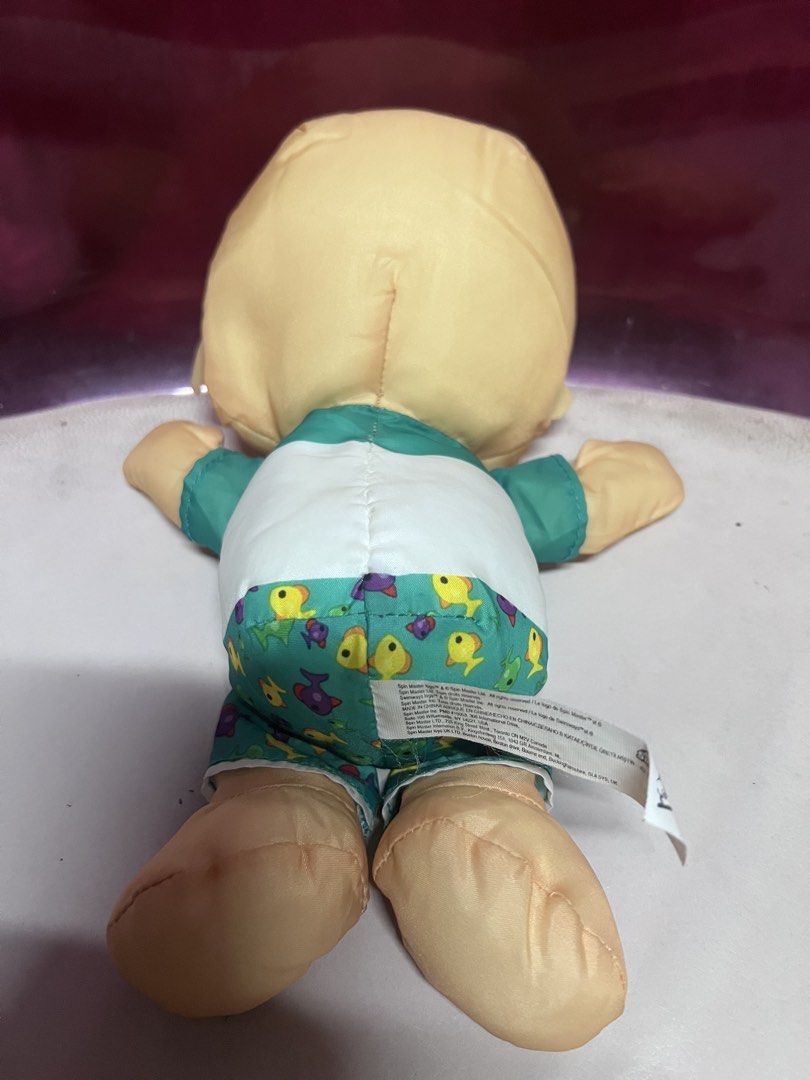 Cocomelon JJ SwimWays Moonbug plush doll toy (Category: Plushies & Soft Toys) located in Bulacan. Submitted by haven_plushie_dolls.888 (Listing ID 1470431097, Image 2). Description: - Official CoComelon JJ plush doll by SwimWays and Moonbug - Wears a green and white palm tree t-shirt and blue swim shorts with yellow and purple fish - Made with a soft fabric body, printed facial features, and signature yellow hair tuft - Original brand tag attache