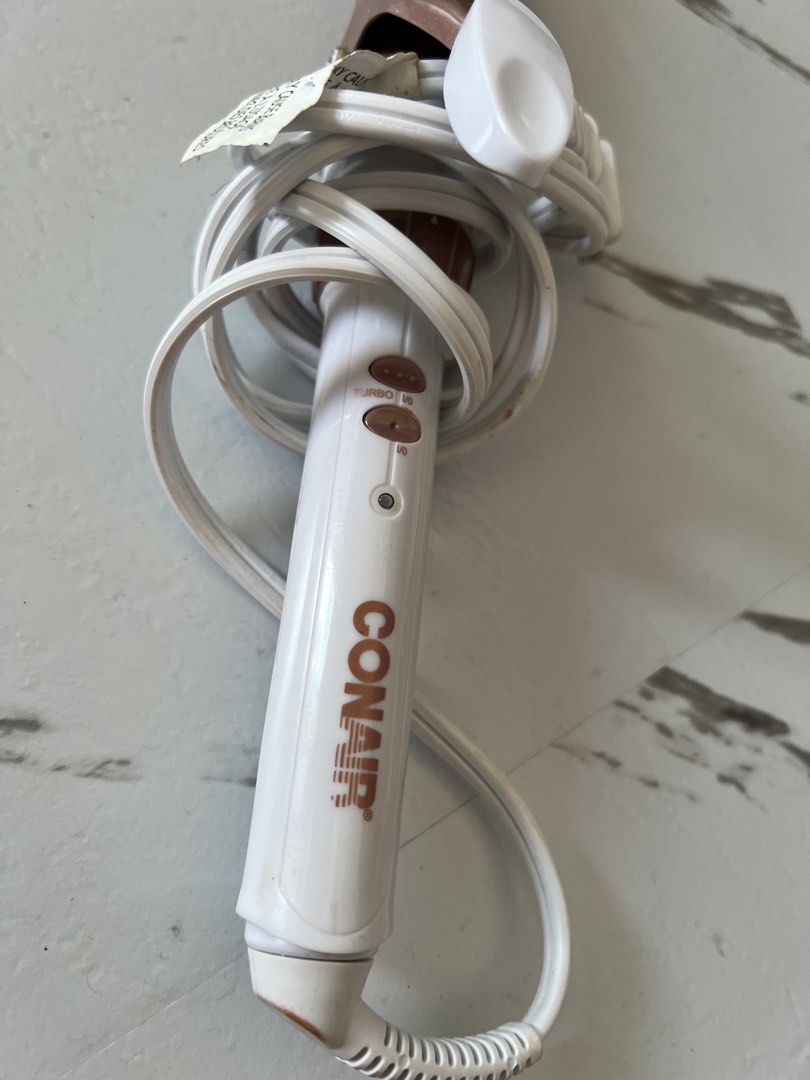 Curling Iron (Category: Hair) located in Taytay. Submitted by cris-ann (Listing ID 1470358198, Image 1). Description: - Brand: Conair Curling Iron - Color: Aesthetic White & Rose Gold - Features: Metallic spring clamp barrel, turbo button, on/off switch, and indicator light - Plug Type: Standard PH two-prong plug with white cord (built-in cord wrap for easy storage) - Condition: Good working conditions - MOP: Cash - SF: Buyer shoulders shipping f