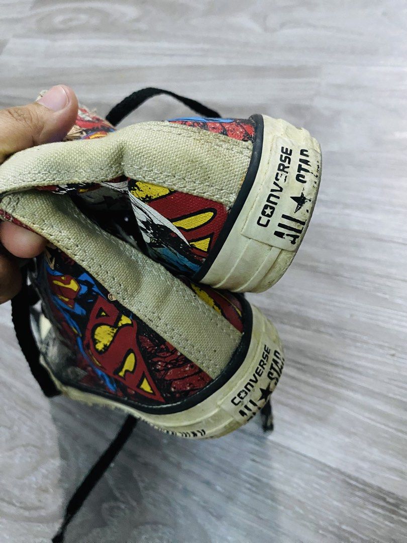 Converse Superman All Star High Top Sneakers (Category: Babies & Kids Fashion) located in Caloocan City. Submitted by lovemyclothes21 (Listing ID 1470455335, Image 2). Description: - Brand: Converse All Star - Style: High-top sneakers with Superman comic print graphics - Details: Black laces, white toe caps, text printed along midsoles, and iconic Superman logo on tongue tags - Material: Classic canvas upper and durable rubber soles - Condition: 